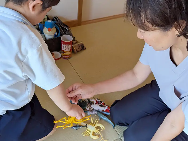 【大阪府池田市石橋の鍼灸院はりとおきゅうとエム】幼稚園くらいの子どもに刺さない鍼ていしんを使って小児はり治療をしている風景